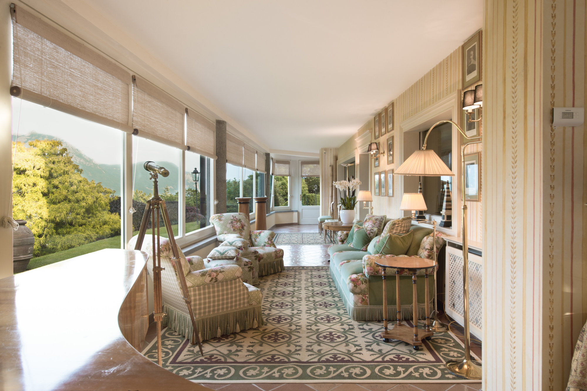 Sunlit sitting room with floral sofas and telescope